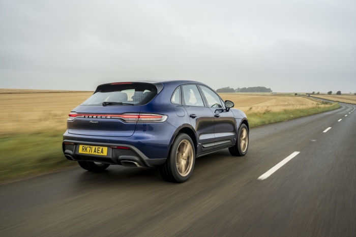 Blue Porsche Macan driving on a country road