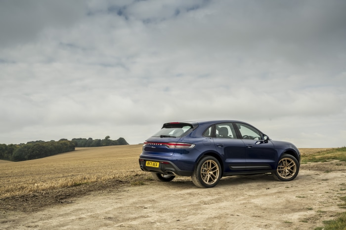 Blue Porsche Macan SUV on a dirt road