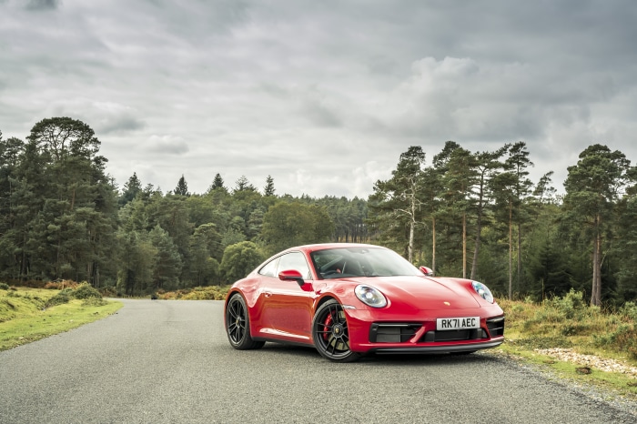 Red Porsche 911 Carrera GTS on a Forest Road