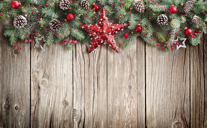 Christmas garland with ornaments and pine cones on wood