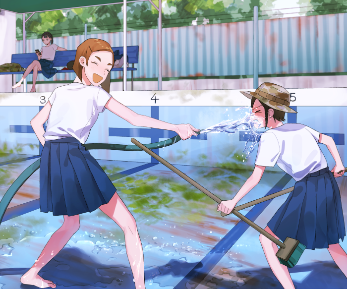 Girls playing with a hose at a swimming pool