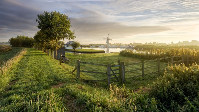 Windmill and boats on a canal in Norfolk, England