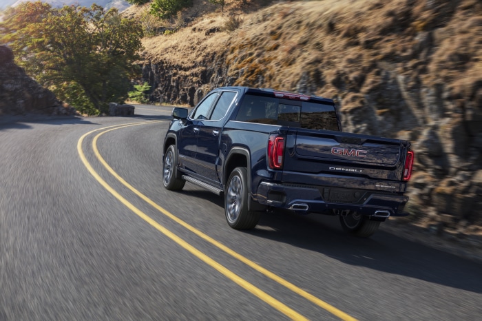 GMC Sierra Denali pickup truck driving on a winding road