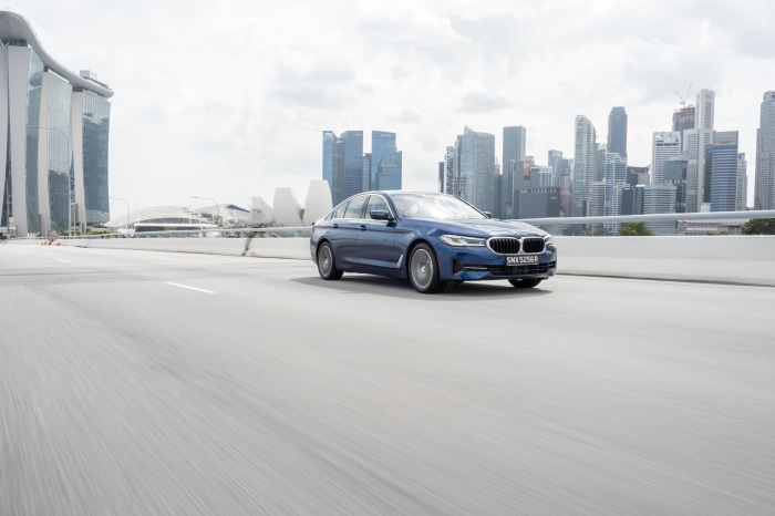 Blue BMW 5 Series 530e Luxury Line driving in Singapore