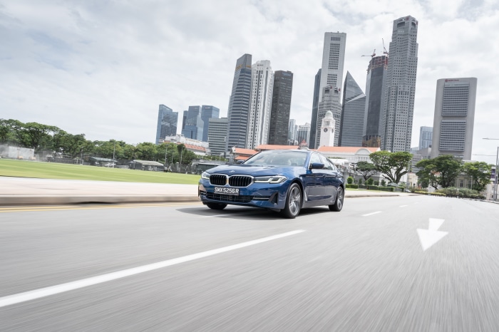 Blue BMW 5 Series 530e Luxury Line driving in city