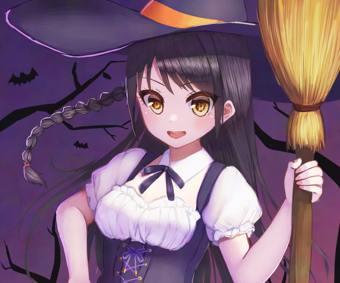 Girl dressed as a witch holding a broom