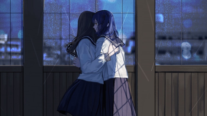 Two schoolgirls hugging by a rainy window