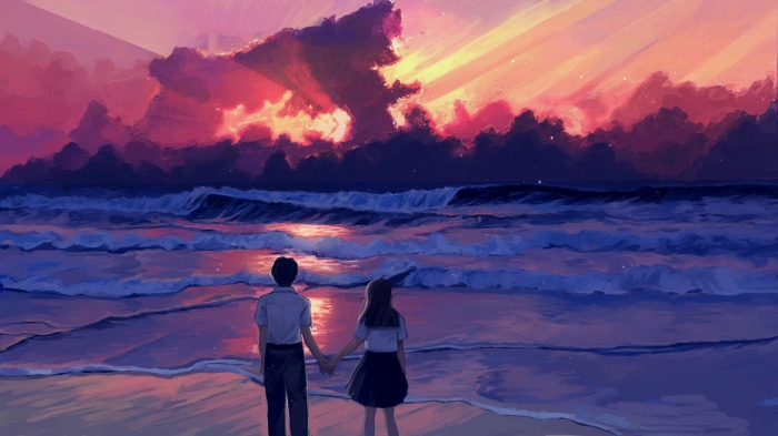 Couple holding hands on beach at sunrise