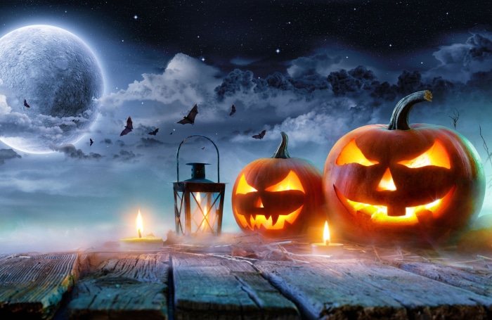 Halloween pumpkins and lantern on a wooden table under the moon