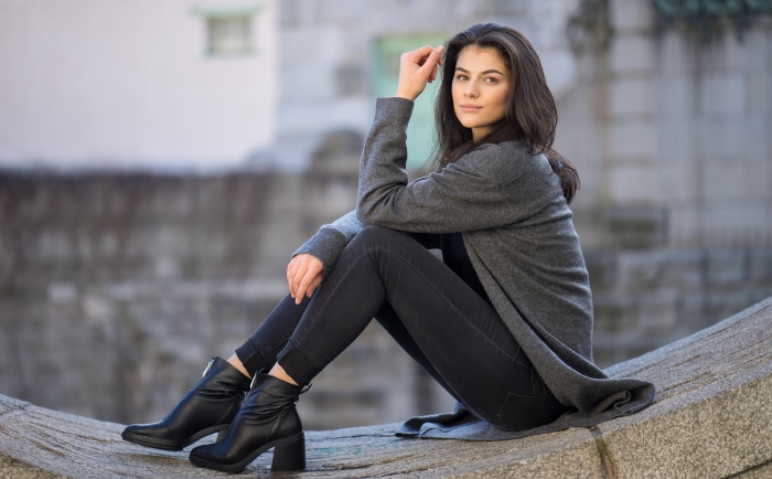 Woman with black hair wearing a grey cardigan