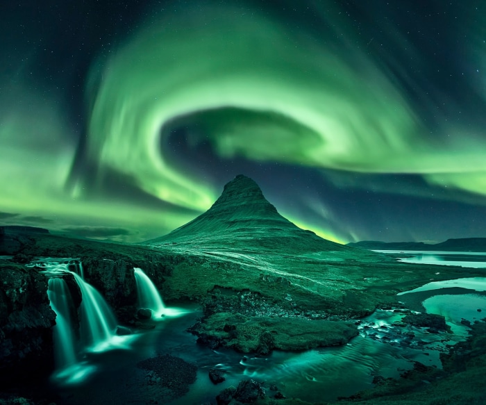 Aurora Borealis over Kirkjufell mountain and Kirkjufoss waterfall in Iceland at night