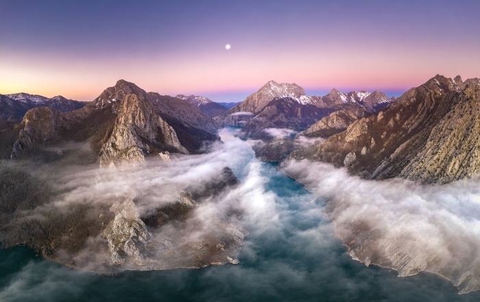 Mountain landscape with river and fog at sunrise