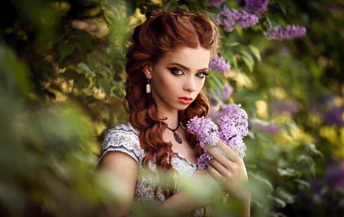 Redhead woman with lilac flowers