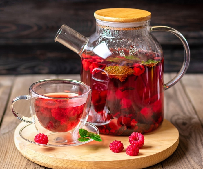 Raspberry and mint infused tea in a glass teapot and cup