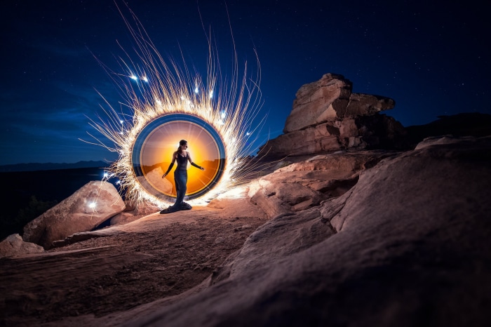 Woman in a portal of sparks at night