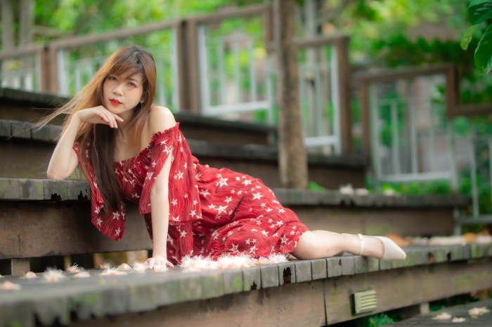 Asian woman in red dress on wooden stairs