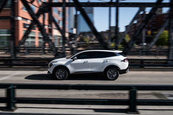 White Kia Sportage SX 4K driving on a bridge