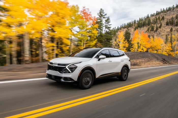White Kia Sportage SX 4K driving on a road