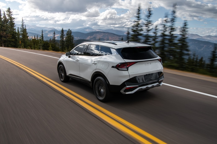 White Kia Sportage SX driving on mountain road