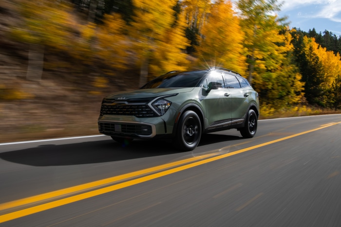 Green Kia Sportage X-Pro 4K driving on a road