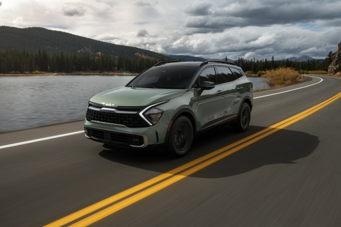 Green Kia Sportage X-Pro 4K driving on a road