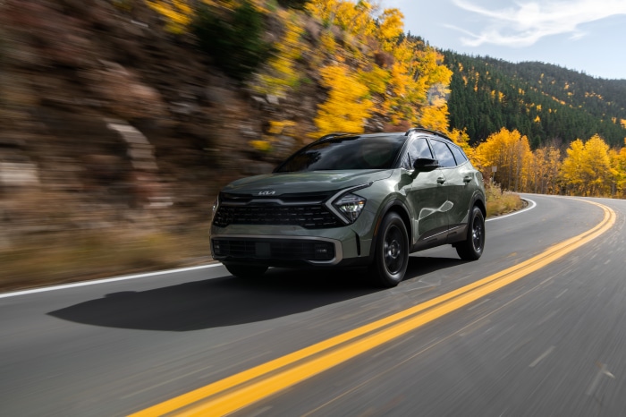 Green Kia Sportage X-Pro 4K driving on a mountain road