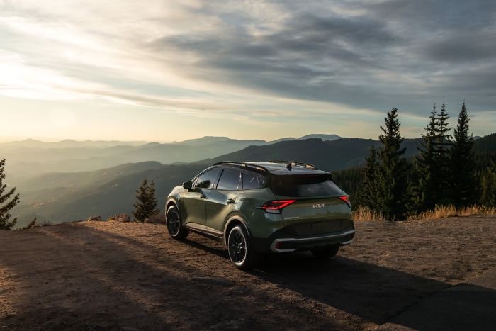 Green Kia Sportage X-Pro 4K SUV on mountain overlook