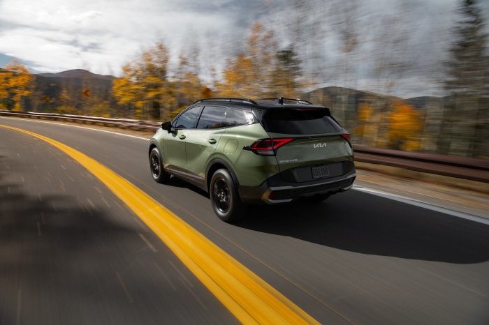 Green Kia Sportage X-Pro 4K driving on a road