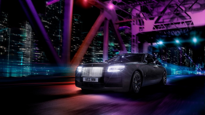 Rolls-Royce Black Badge Ghost driving on a bridge at night