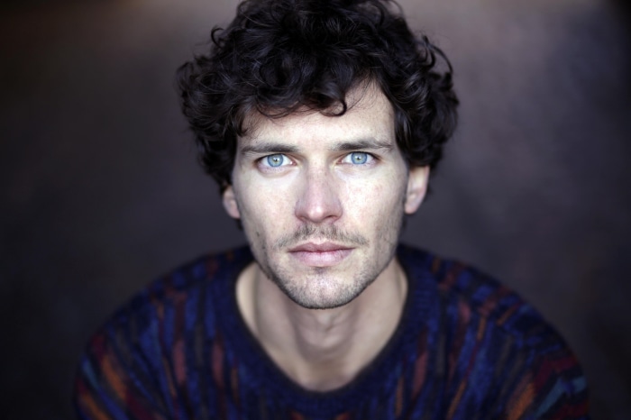 Man with curly hair and blue eyes
