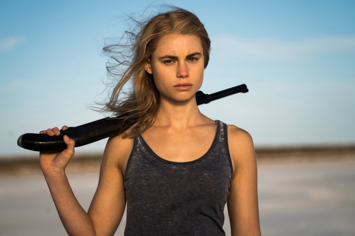 Lucy Fry holding a rifle