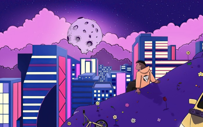 Man sitting on a hill overlooking a futuristic city at night