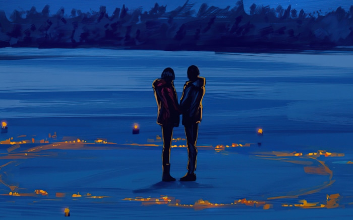 Couple holding hands by lanterns at night