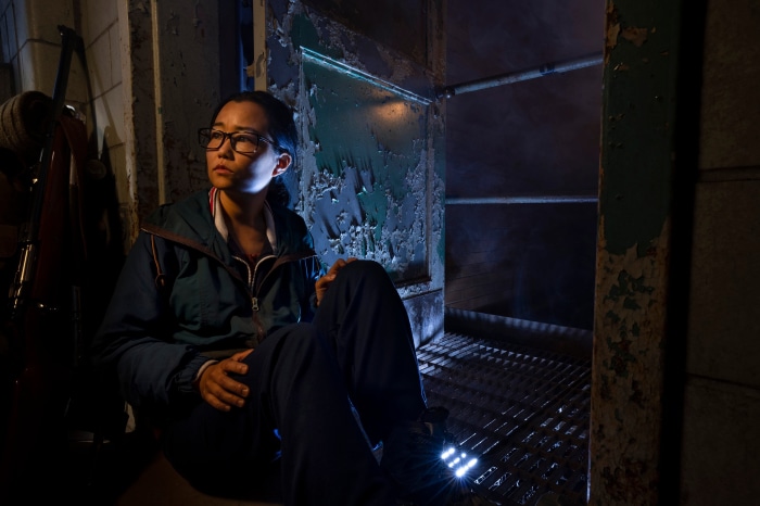 Woman in dark room with peeling paint