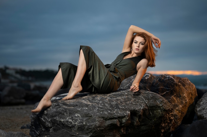 Redhead Model Posing on Rocks at Dusk 4K