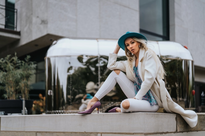 Woman in hat and coat sitting by Airstream