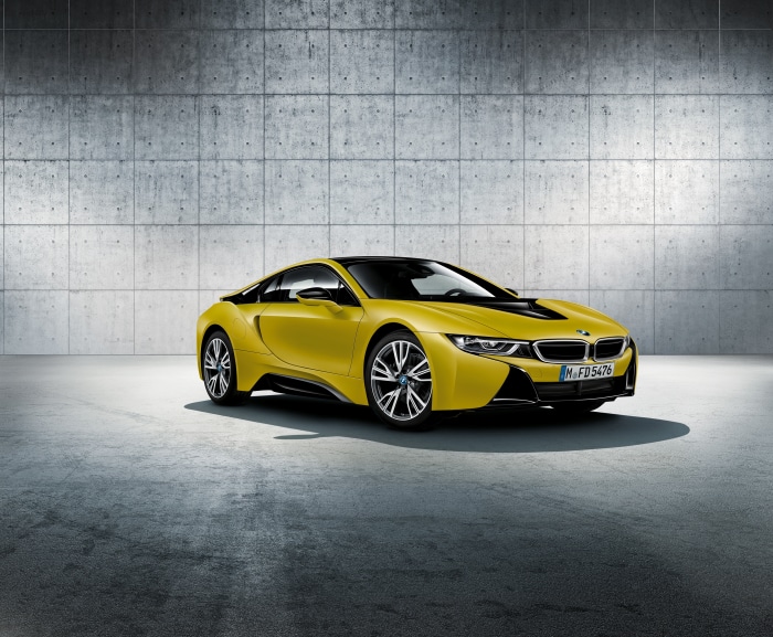 Yellow BMW i8 parked in a concrete garage