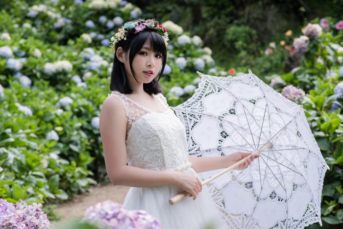 Asian woman in white dress holding umbrella