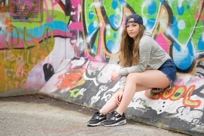 Girl in front of graffiti wall