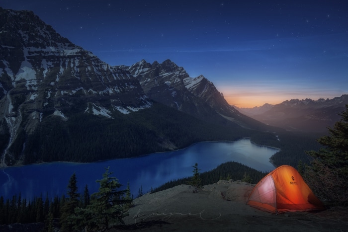 Tent by a lake in the mountains at night