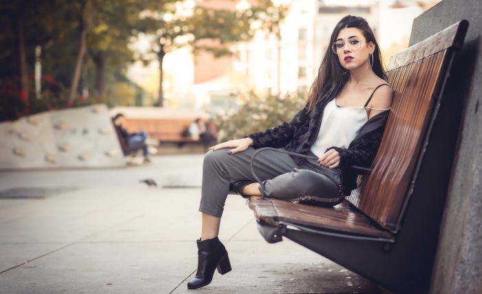 Woman with glasses sitting on a park bench