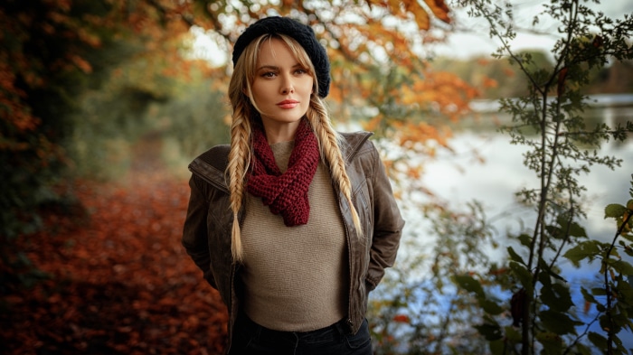 Woman with blonde braids and beret in autumn park