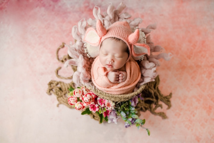 Newborn Baby Sleeping in a Basket with Flowers