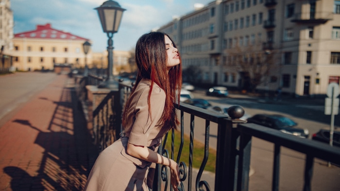 Brunette woman leaning on a railing in a city