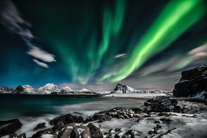 Aurora Borealis over Snowy Mountains and Ocean