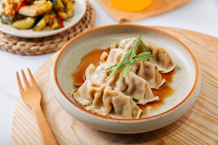 Plate of dumplings with sauce and garnish