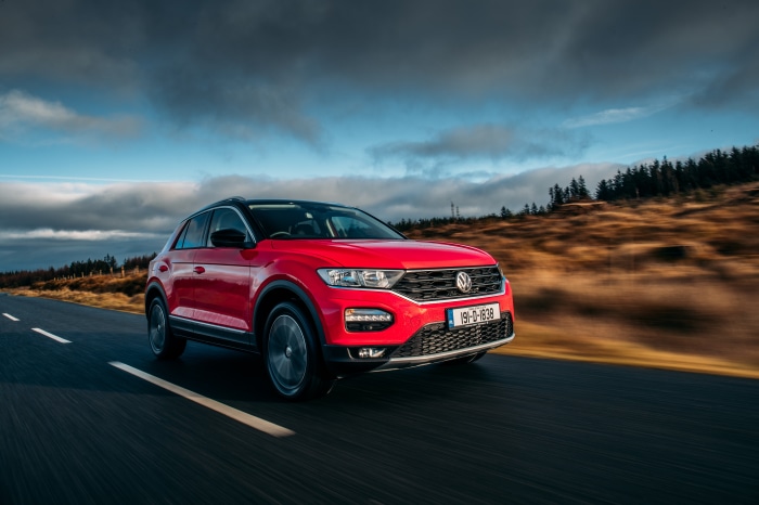 Red Volkswagen T-Roc SUV driving on a road