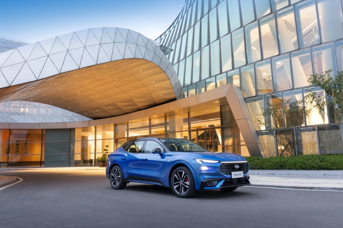 Blue Ford Evos ST-Line 4K parked in front of modern building