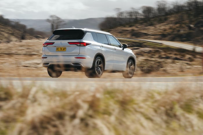 Silver Mitsubishi Outlander driving on a winding road