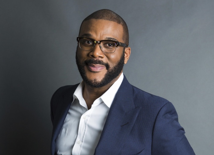 Tyler Perry wearing a suit and glasses
